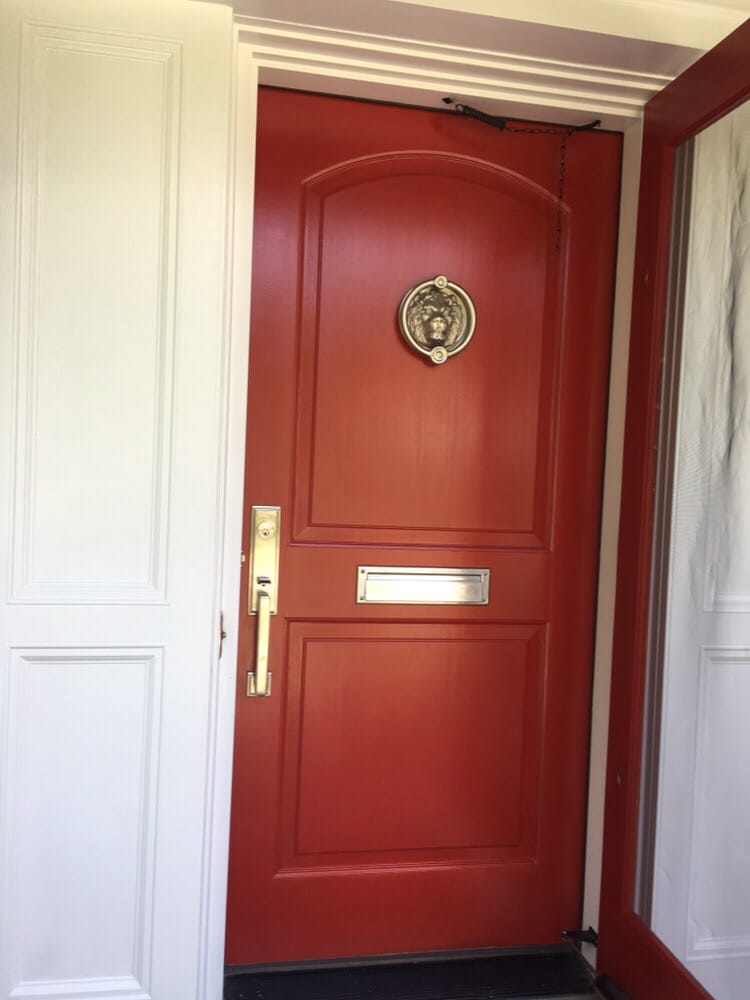 A red door with a small rounded gold frame