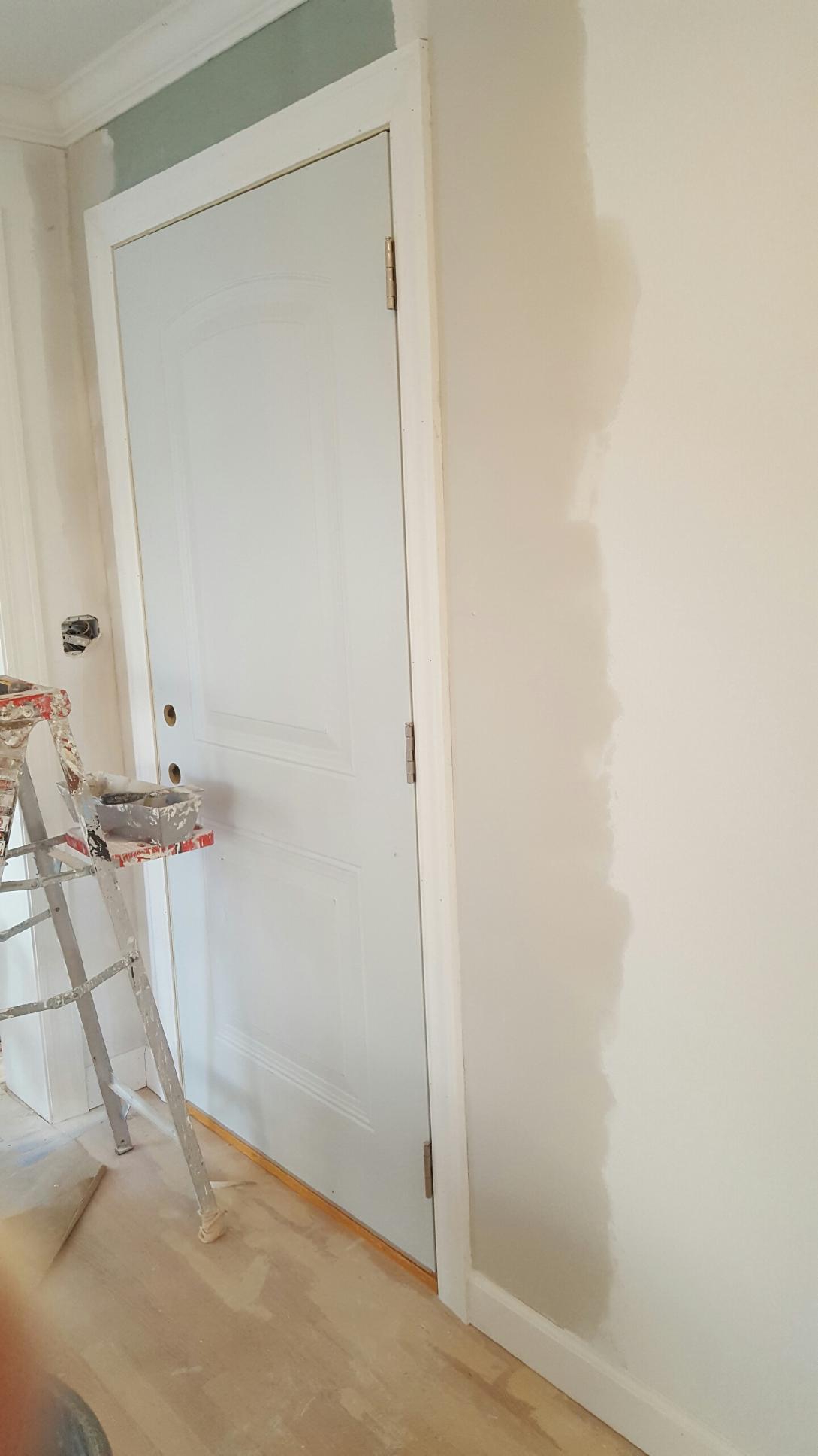 Door being painted along with the wall around it